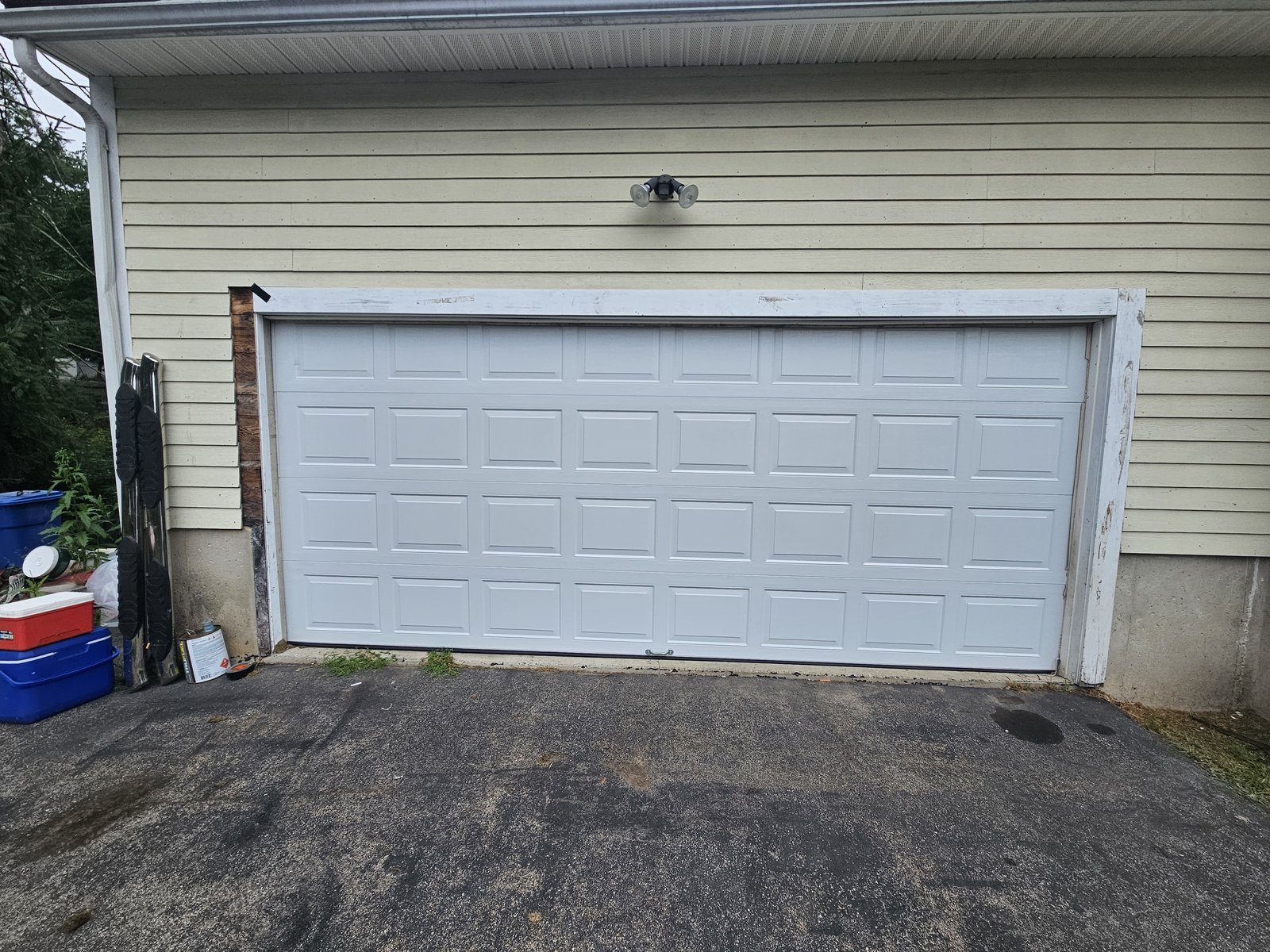 New white raised-panel garage door installed in the same opening