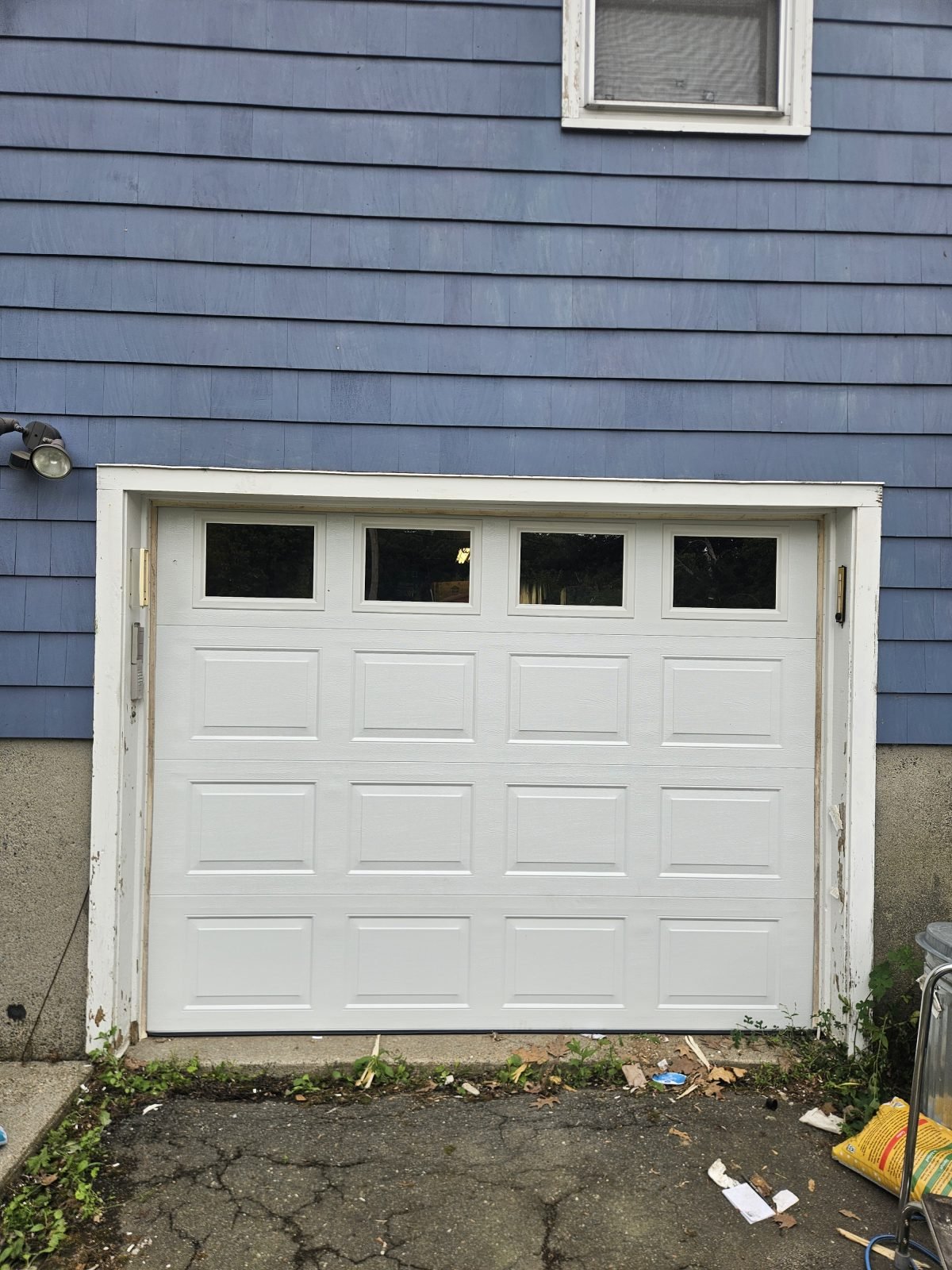 New white raised-panel garage door with windows installed