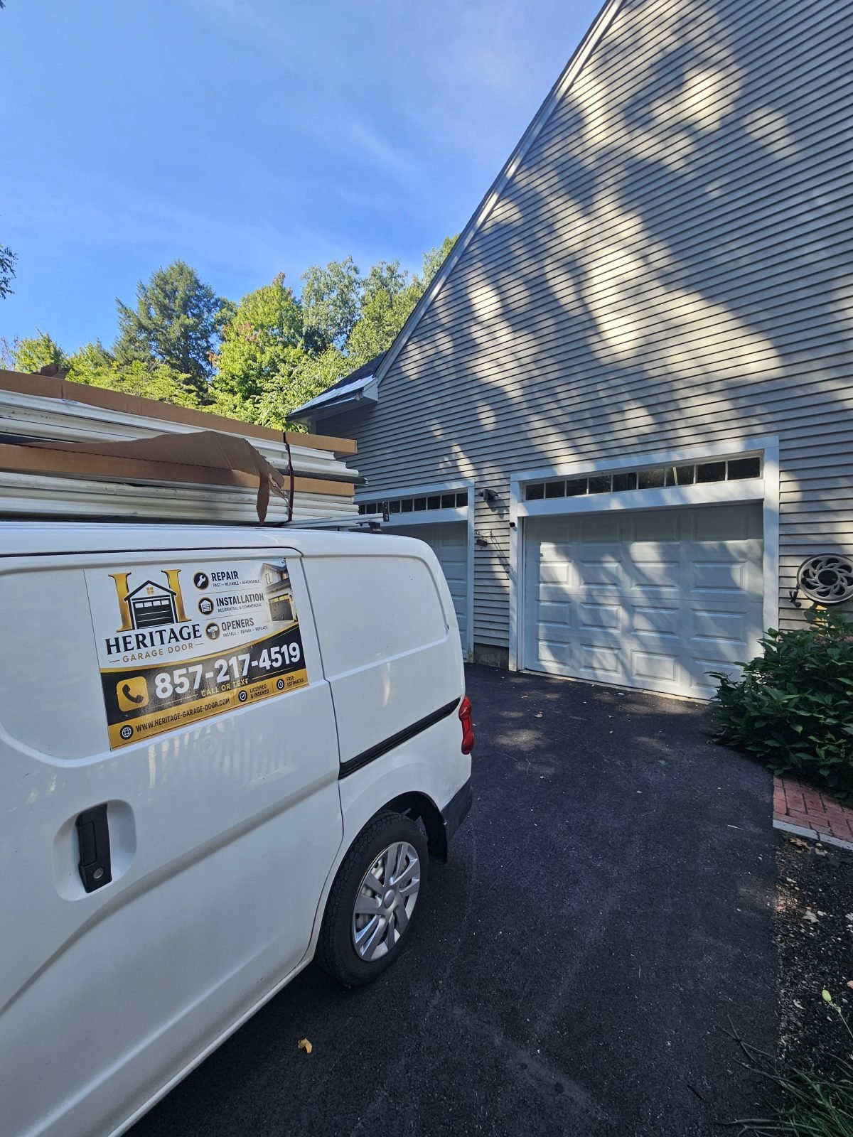 New white raised-panel garage door installed in the same opening