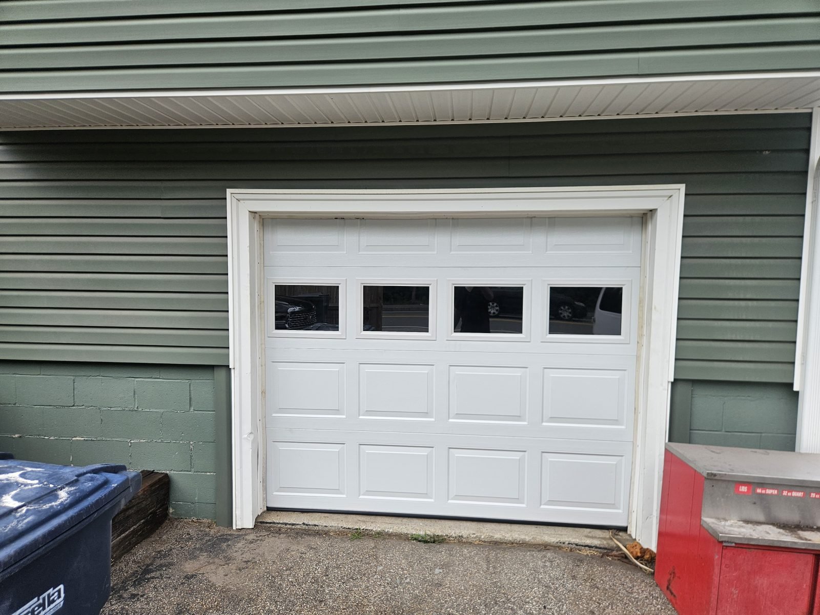 New white raised-panel garage door with windows installed in the same opening